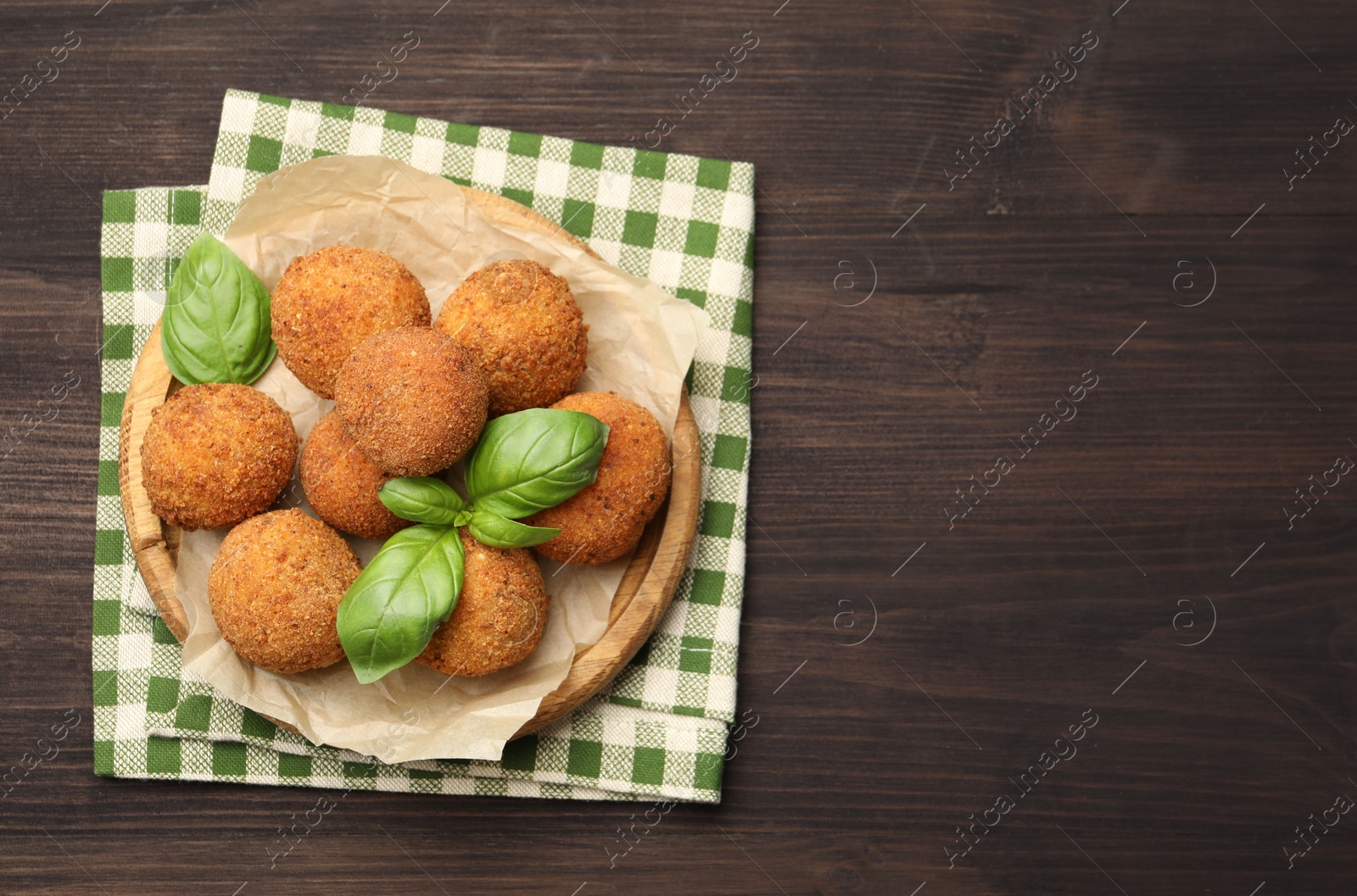 Delicious fried croquette balls with basil on wooden table, top view. Space for text Photo of Delicious fried croquette balls with basil on wooden table, top view. Space for text