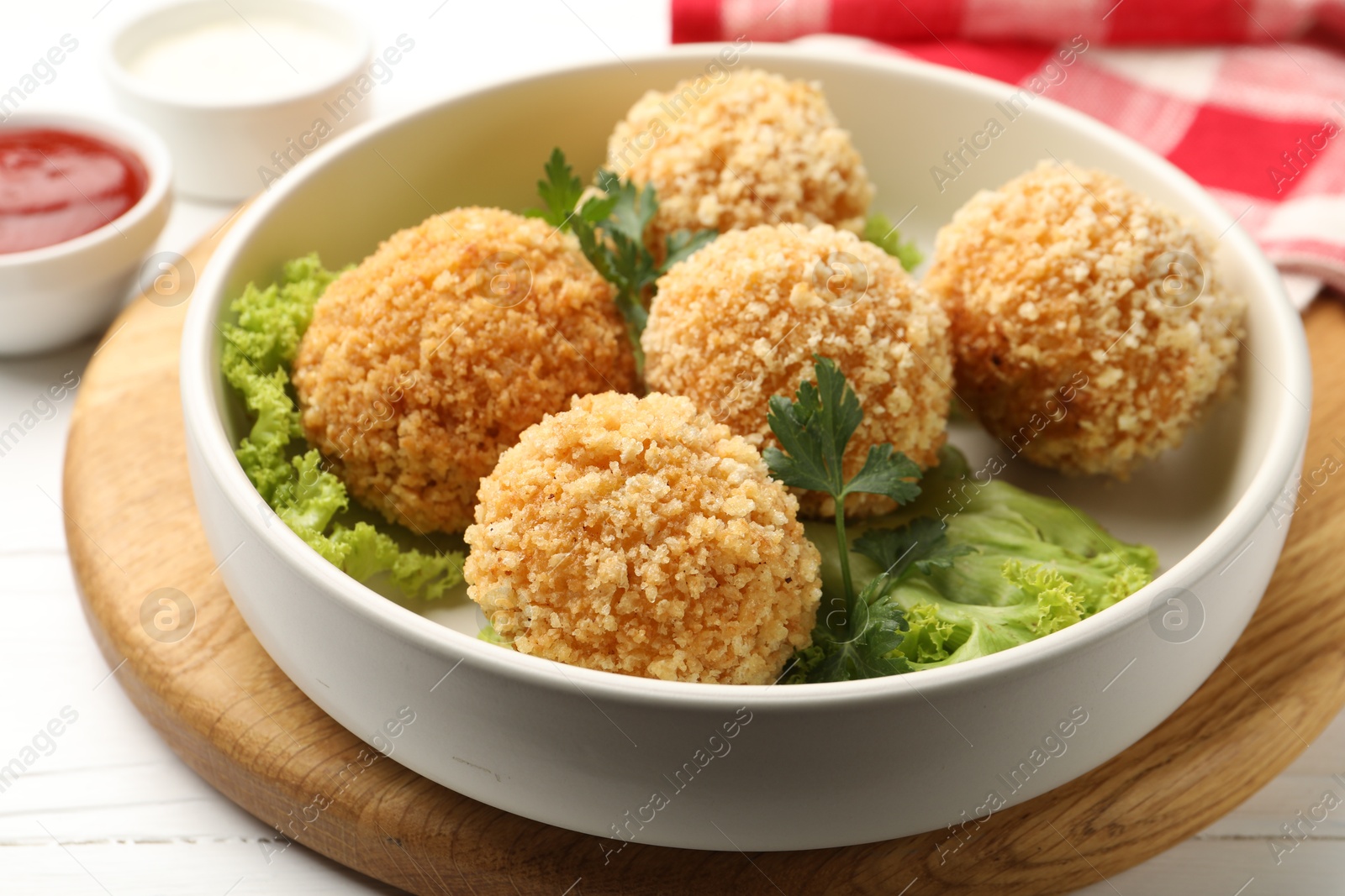 Delicious fried croquette balls with parsley and lettuce on white wooden table, closeup Photo of Delicious fried croquette balls with parsley and lettuce on white wooden table, closeup