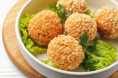 Photo of Delicious fried croquette balls with parsley and lettuce on white wooden table, closeup
