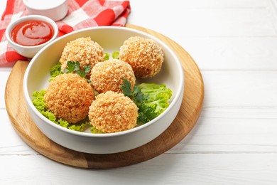 Photo of Delicious fried croquette balls with parsley and lettuce on white wooden table, closeup
