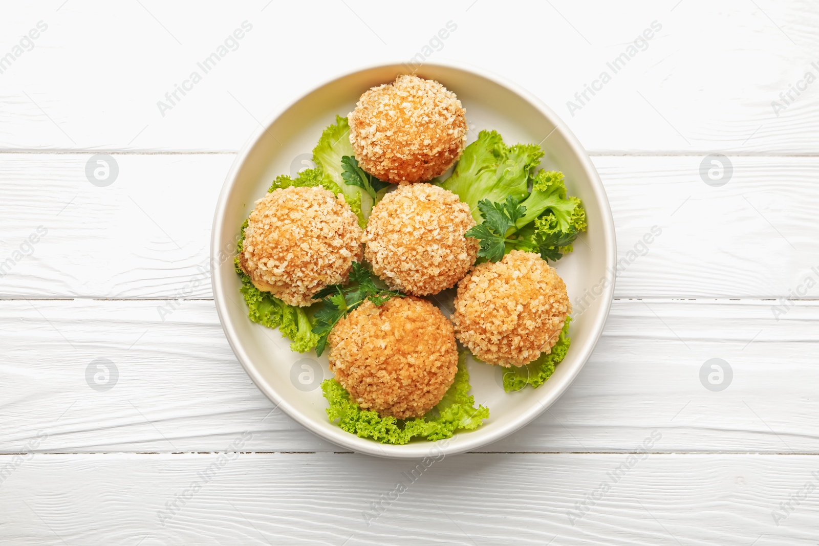 Delicious fried croquette balls with parsley and lettuce on white wooden table, top view Photo of Delicious fried croquette balls with parsley and lettuce on white wooden table, top view
