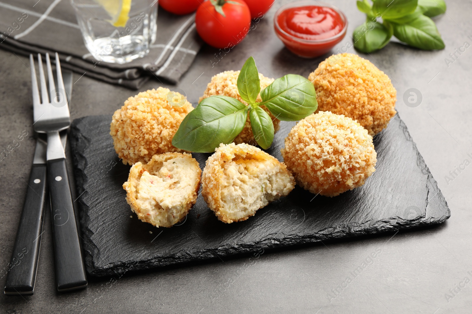 Delicious fried croquette balls with basil on grey table, closeup Photo of Delicious fried croquette balls with basil on grey table, closeup