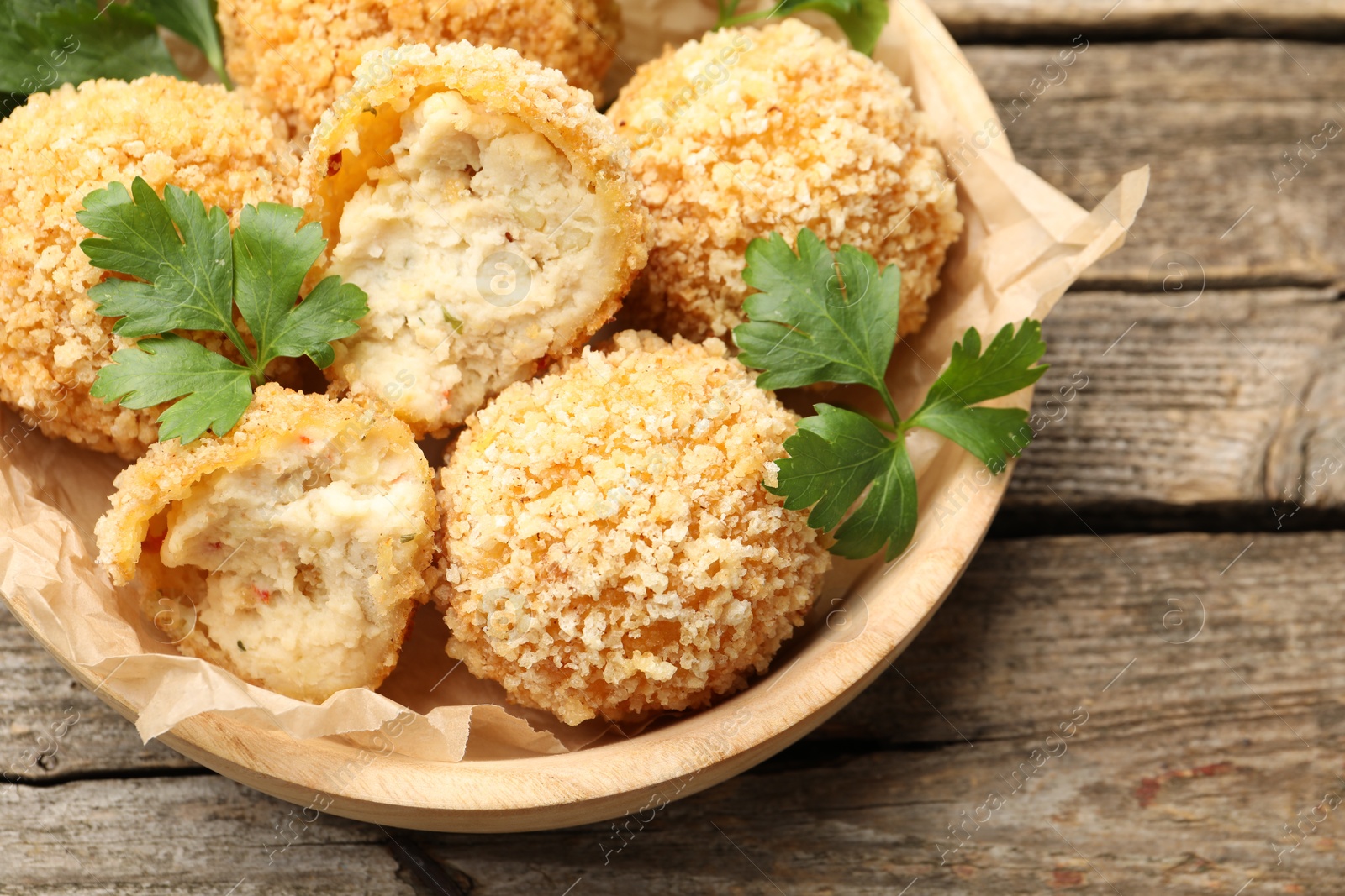 Delicious fried croquette balls with parsley on wooden table, above view Photo of Delicious fried croquette balls with parsley on wooden table, above view