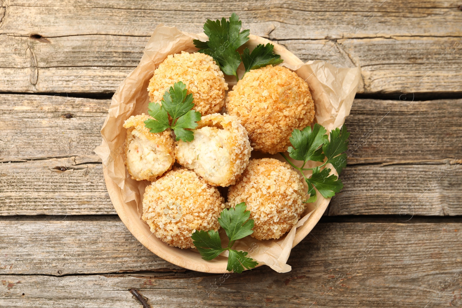 Delicious fried croquette balls with parsley on wooden table, top view Photo of Delicious fried croquette balls with parsley on wooden table, top view