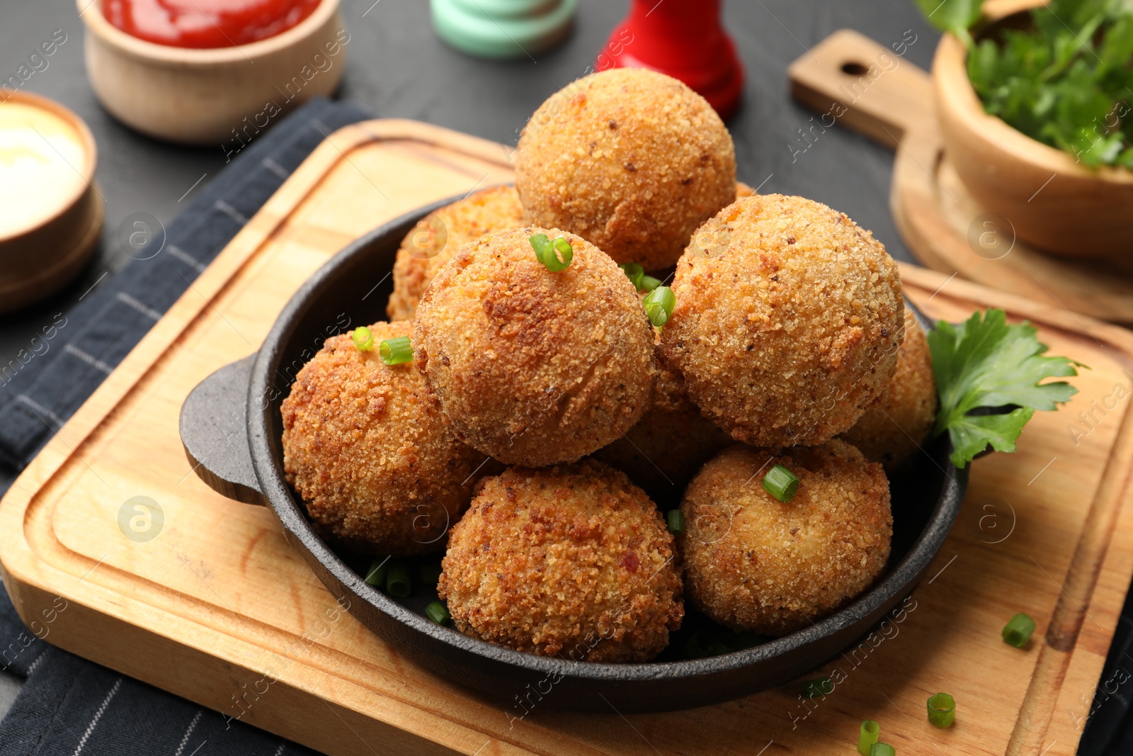 Delicious fried croquette balls with parsley and green onion on grey table, closeup Photo of Delicious fried croquette balls with parsley and green onion on grey table, closeup