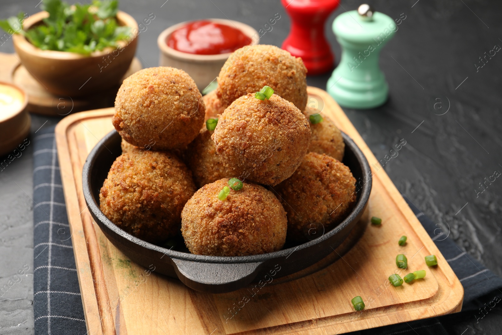 Delicious fried croquette balls with green onion on grey textured table, closeup Photo of Delicious fried croquette balls with green onion on grey textured table, closeup