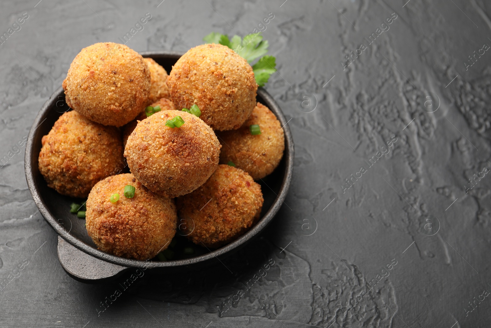 Delicious fried croquette balls with green onion on grey textured table, closeup. Space for text Photo of Delicious fried croquette balls with green onion on grey textured table, closeup. Space for text