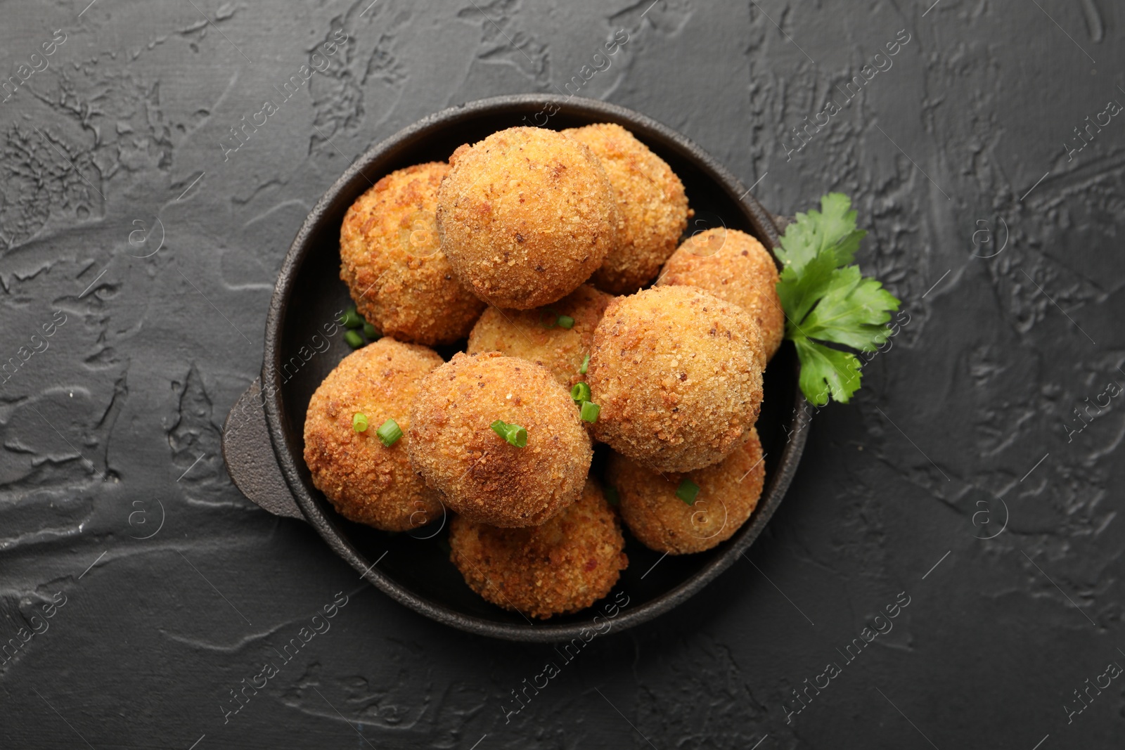 Delicious fried croquette balls with green onion and parsley on grey textured table, top view Photo of Delicious fried croquette balls with green onion and parsley on grey textured table, top view