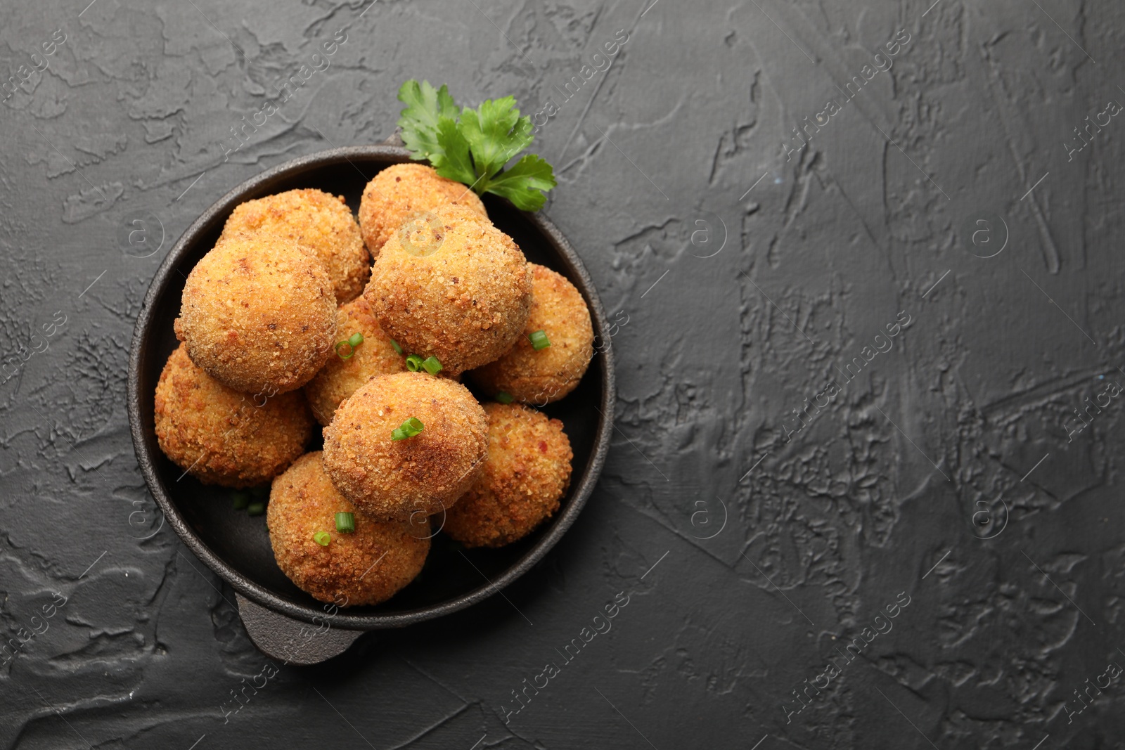 Delicious fried croquette balls with green onion and parsley on grey textured table, top view. Space for text Photo of Delicious fried croquette balls with green onion and parsley on grey textured table, top view. Space for text