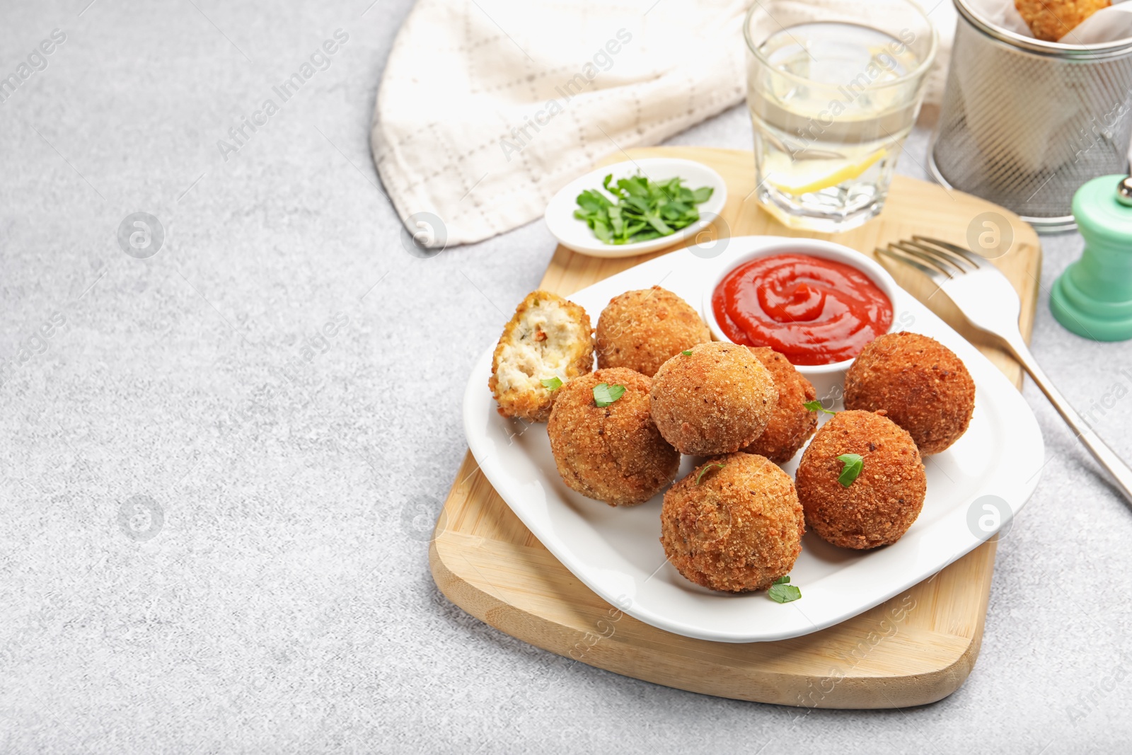 Delicious fried croquette balls with parsley and ketchup on grey textured table, closeup. Space for text Photo of Delicious fried croquette balls with parsley and ketchup on grey textured table, closeup. Space for text