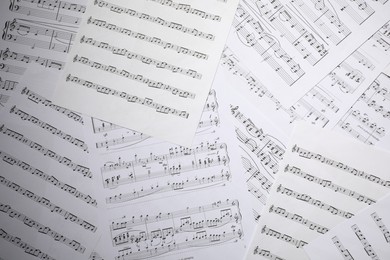 Photo of Sheets with musical notes as background, top view