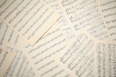 Photo of Sheets with musical notes as background, top view