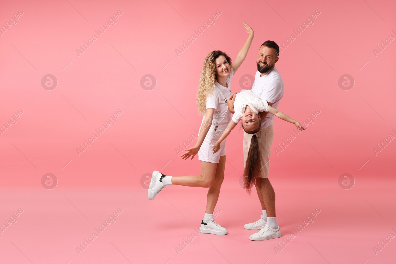 Happy family posing on pink background. Space for text Photo of Happy family posing on pink background. Space for text
