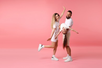 Photo of Happy family posing on pink background. Space for text