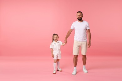Photo of Family. Happy father and his daughter on pink background. Space for text