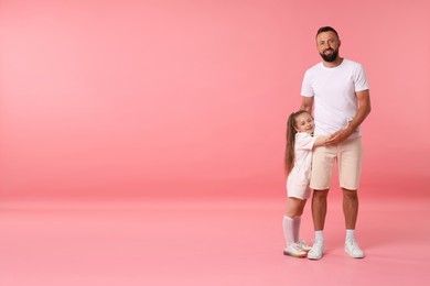 Photo of Family. Happy father and his daughter on pink background. Space for text