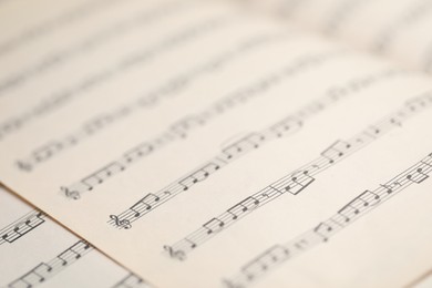 Photo of Sheets with musical notes as background, closeup