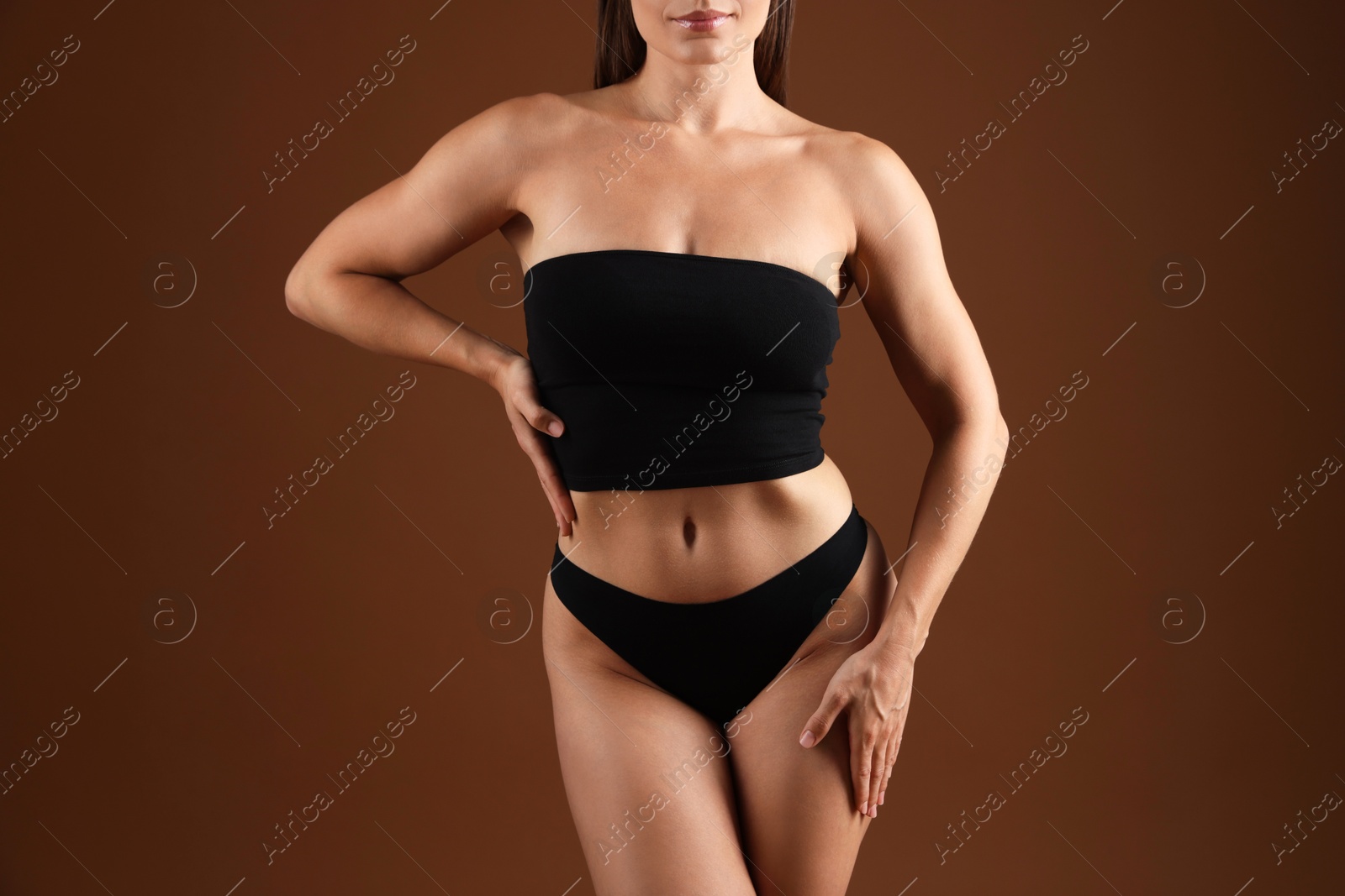 Fit woman with perfect body on brown background, closeup Photo of Fit woman with perfect body on brown background, closeup