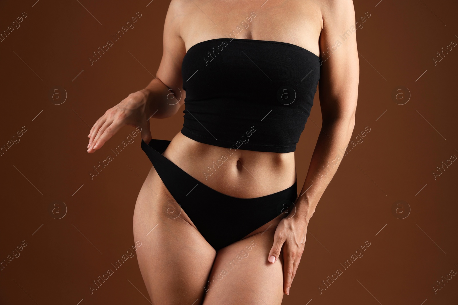 Fit woman with perfect body on brown background, closeup Photo of Fit woman with perfect body on brown background, closeup