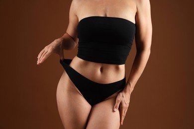 Photo of Fit woman with perfect body on brown background, closeup