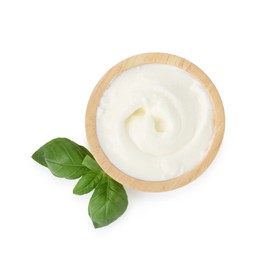 Photo of Tasty yoghurt in bowl and basil isolated on white, top view