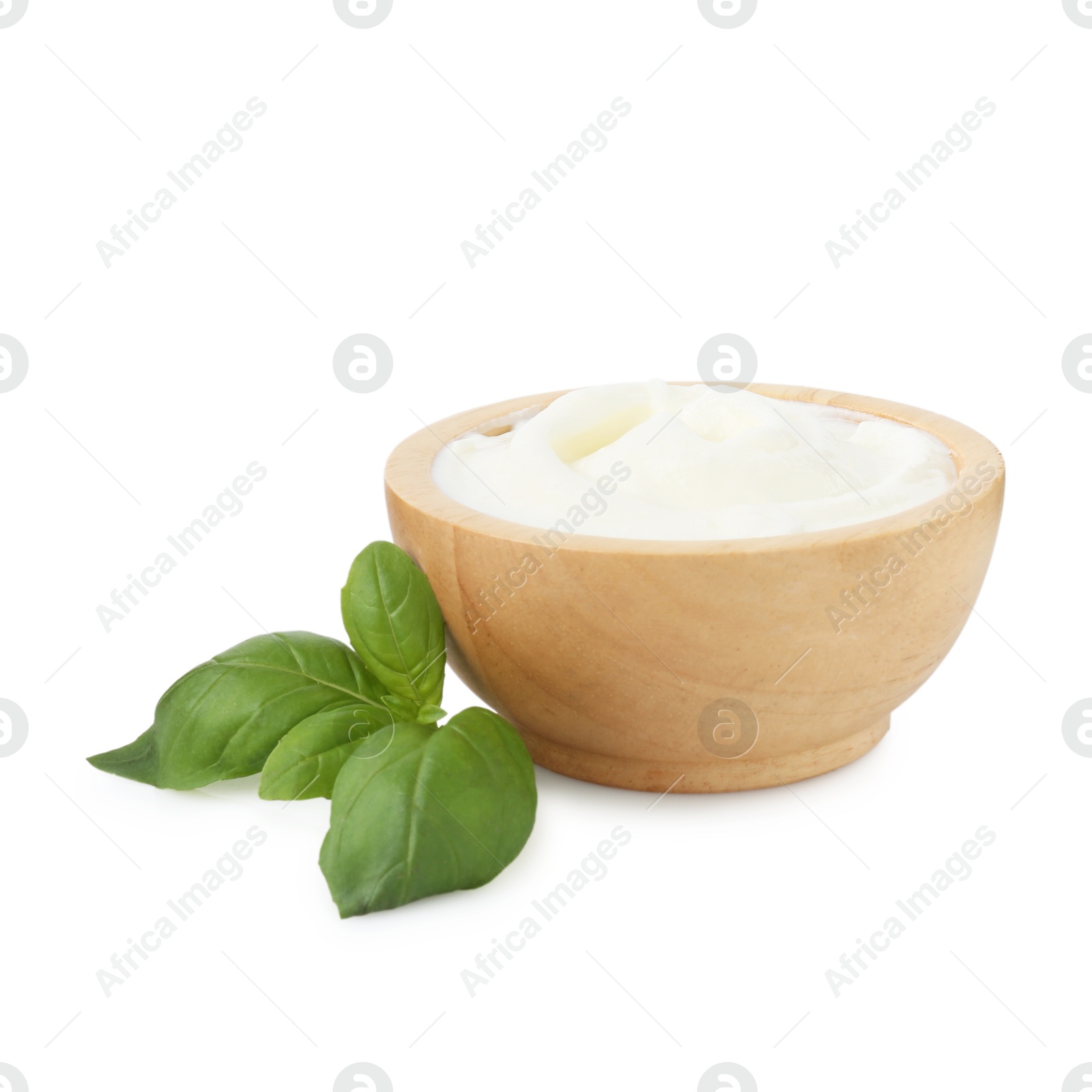 Tasty yoghurt in bowl and basil isolated on white Photo of Tasty yoghurt in bowl and basil isolated on white
