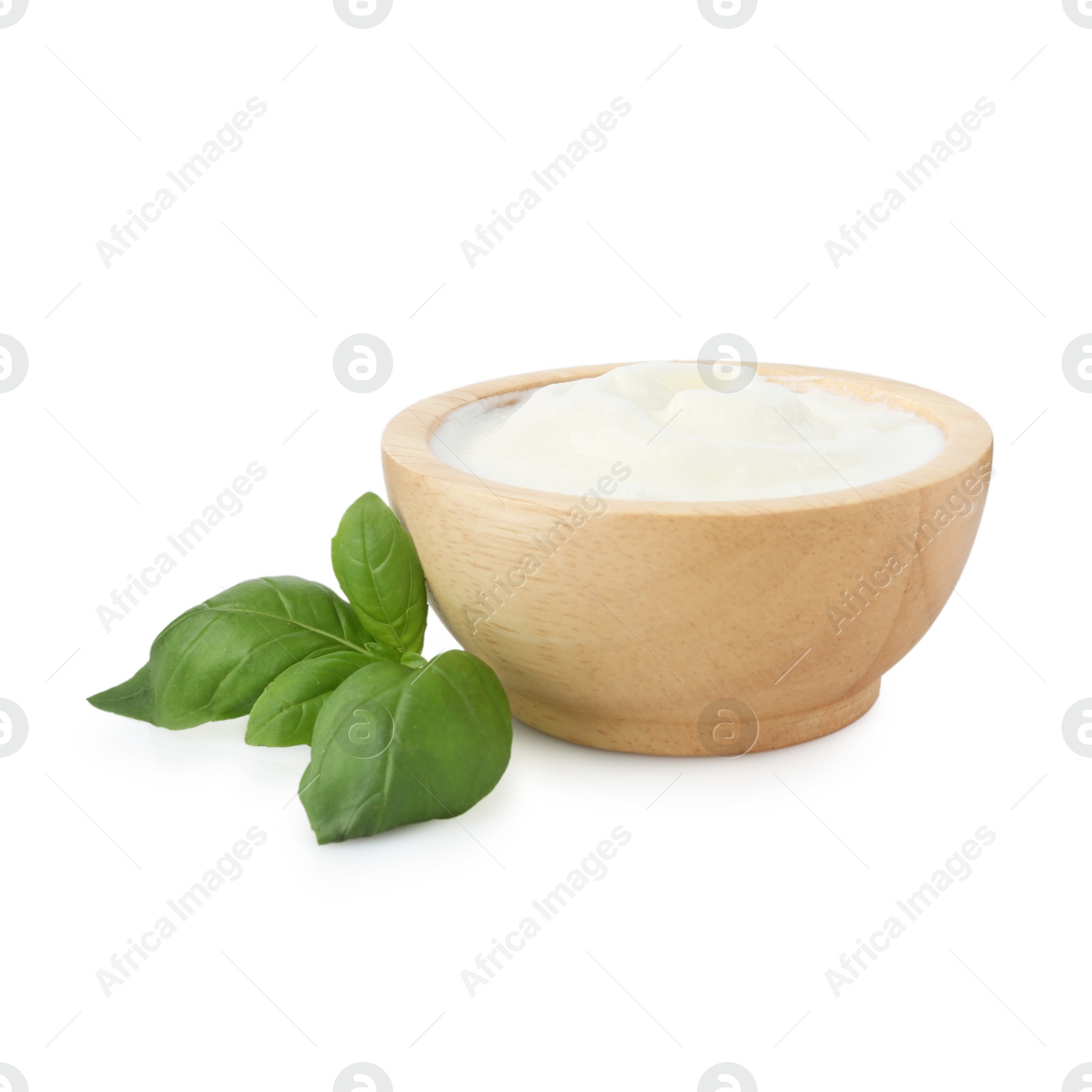 Tasty yoghurt in bowl and basil isolated on white Photo of Tasty yoghurt in bowl and basil isolated on white