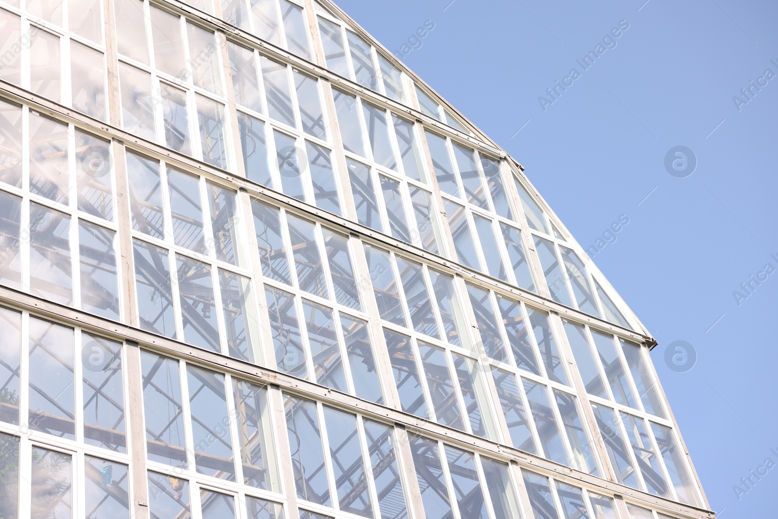Modern building with many windows against blue sky, low angle view Photo of Modern building with many windows against blue sky, low angle view