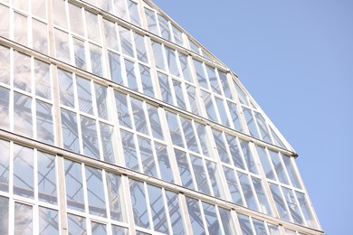 Photo of Modern building with many windows against blue sky, low angle view