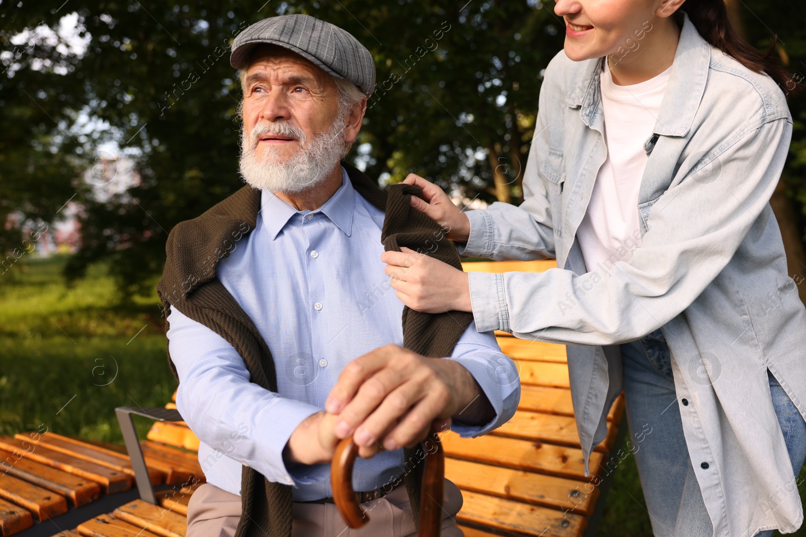 Smiling caregiver supporting elderly man with walking cane outdoors, closeup Photo of Smiling caregiver supporting elderly man with walking cane outdoors, closeup