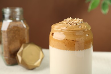 Photo of Delicious dalgona coffee in glass on blurred background, closeup. Space for text