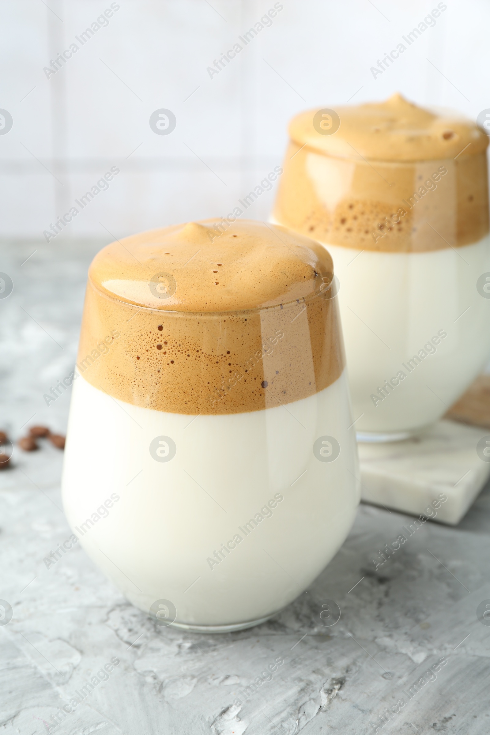 Photo of Delicious dalgona coffee in glasses on grey table, closeup