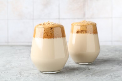 Photo of Delicious dalgona coffee in glasses on grey table, closeup