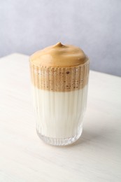 Photo of Delicious dalgona coffee in glass on light table, closeup