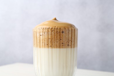 Photo of Delicious dalgona coffee in glass on blurred background, closeup