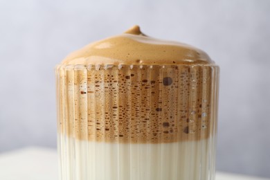 Photo of Delicious dalgona coffee in glass on blurred background, closeup