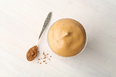 Photo of Delicious dalgona coffee in glass and granules on light table, flat lay