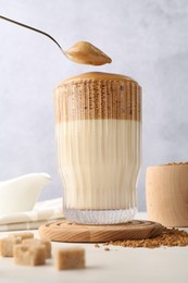 Photo of Taking cream from delicious dalgona coffee at light table, low angle view