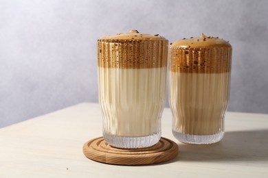 Photo of Delicious dalgona coffee in glasses on light table, closeup