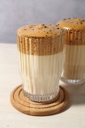 Photo of Delicious dalgona coffee in glasses on light table, closeup