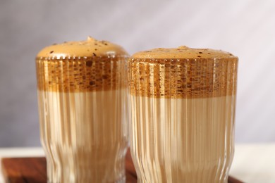 Photo of Delicious dalgona coffee in glasses on table, closeup