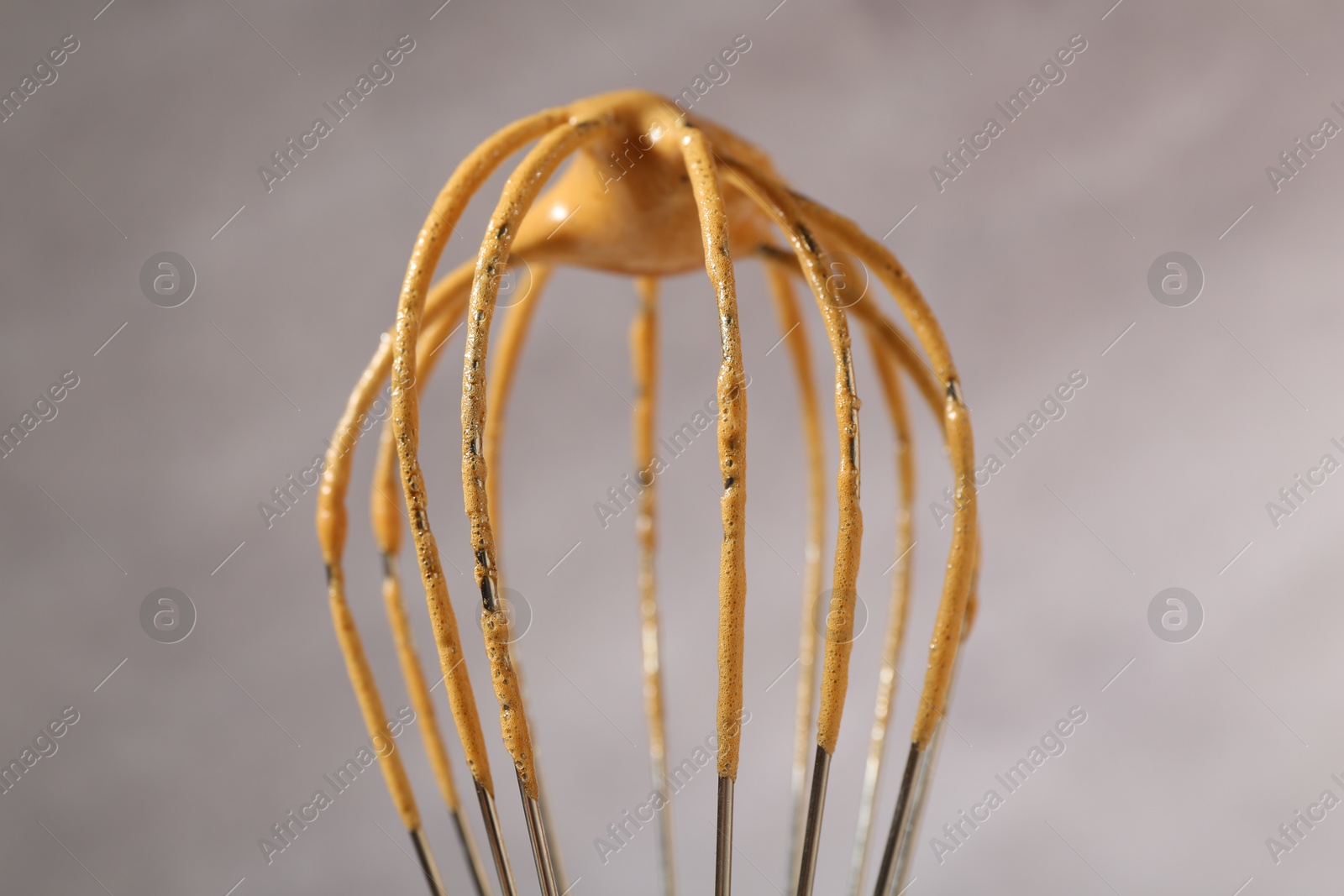 Making delicious dalgona coffee. Whisk with cream on blurred background, closeup Photo of Making delicious dalgona coffee. Whisk with cream on blurred background, closeup