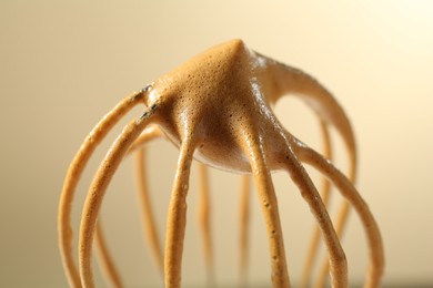 Photo of Making delicious dalgona coffee. Whisk with cream on beige background, closeup