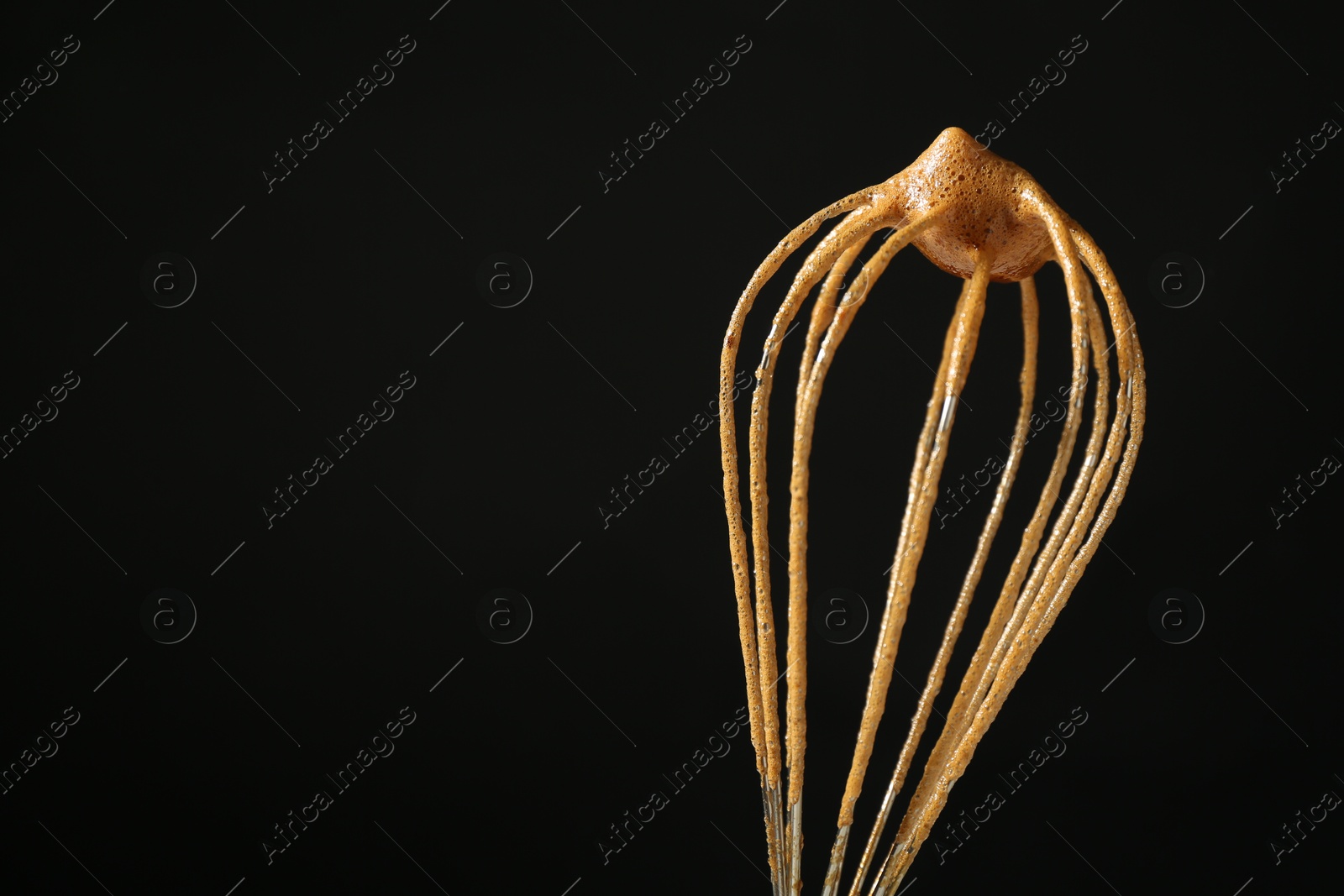 Making delicious dalgona coffee. Whisk with cream on black background, closeup. Space for text Photo of Making delicious dalgona coffee. Whisk with cream on black background, closeup. Space for text