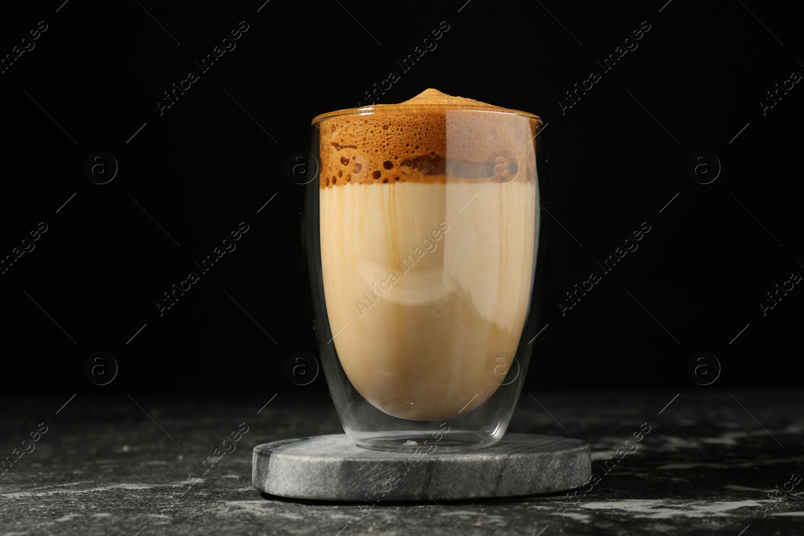 Delicious dalgona coffee in glass on dark marble table Photo of Delicious dalgona coffee in glass on dark marble table