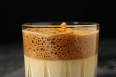 Photo of Delicious dalgona coffee in glass on blurred background, closeup