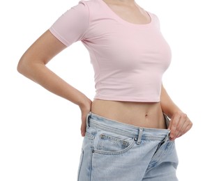 Photo of Woman wearing old jeans after weight loss on white background, closeup