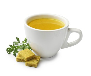 Photo of Aromatic bouillon cubes, broth and parsley isolated on white
