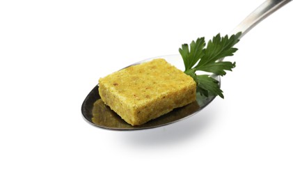 Photo of Aromatic bouillon cube, parsley and spoon isolated on white