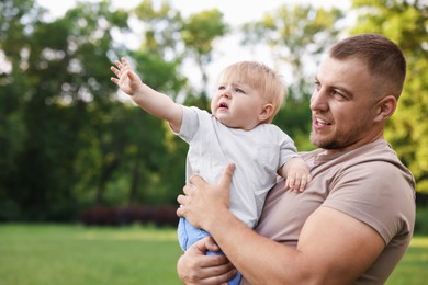 Photo of Dad with his cute newborn baby outdoors. Happy Father's Day